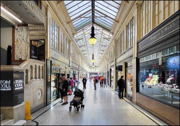 A group of people walking in a shopping mall
Description automatically generated