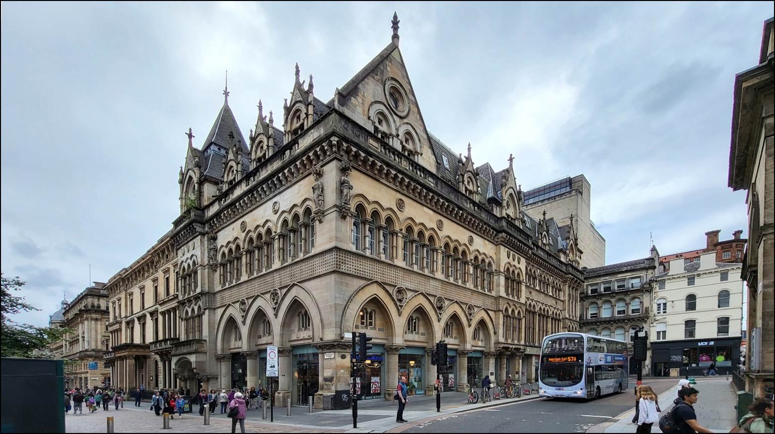 A large building with a bus on the street
Description automatically generated