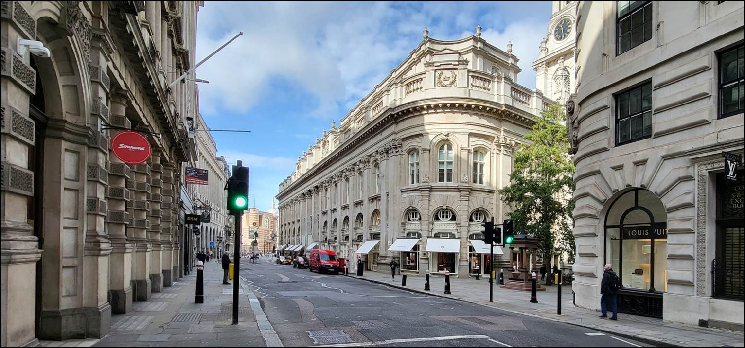 A street with a building and traffic lights
Description automatically generated