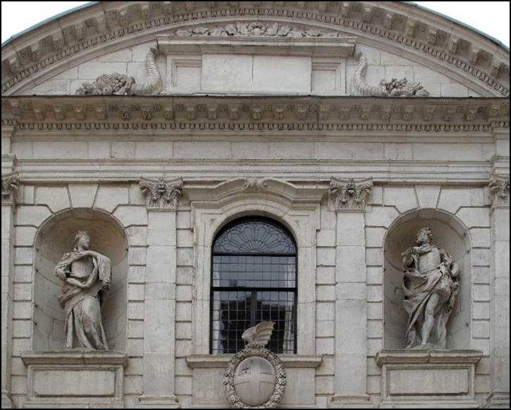 A stone building with statues on the front
Description automatically generated