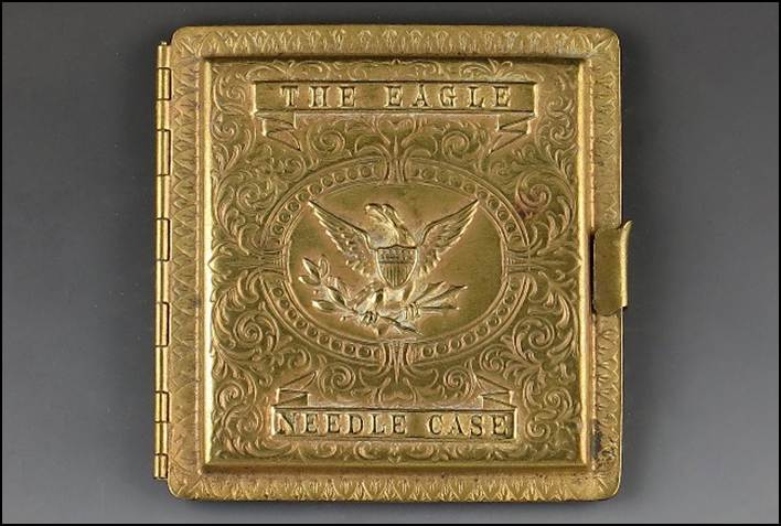 A gold metal case with a eagle on it
Description automatically generated