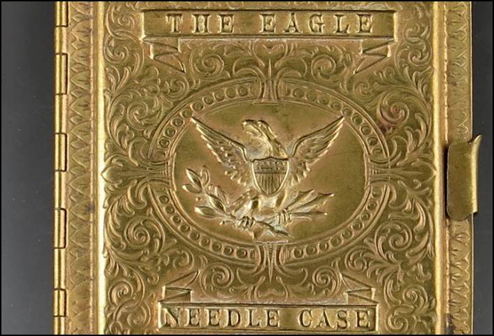 A gold metal case with a eagle on it
Description automatically generated