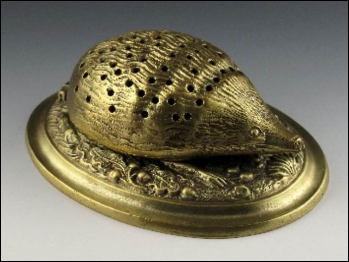 A gold object with holes on it
Description automatically generated