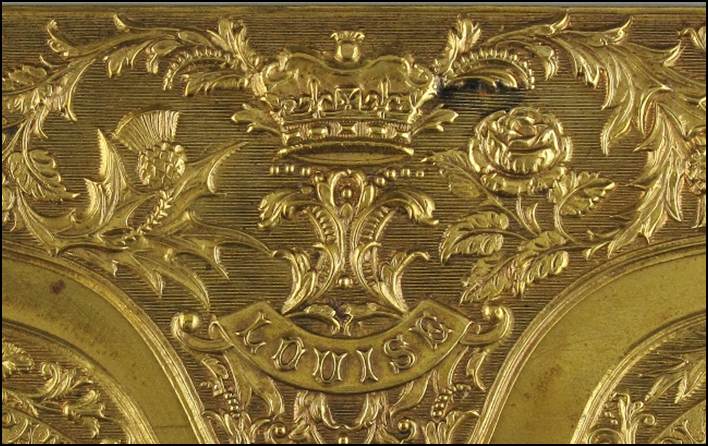 A gold rectangular object with a design

Description automatically generated