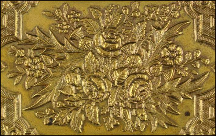 A gold rectangular object with a design

Description automatically generated