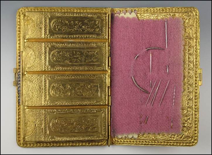 A gold case with needlework
Description automatically generated with medium confidence